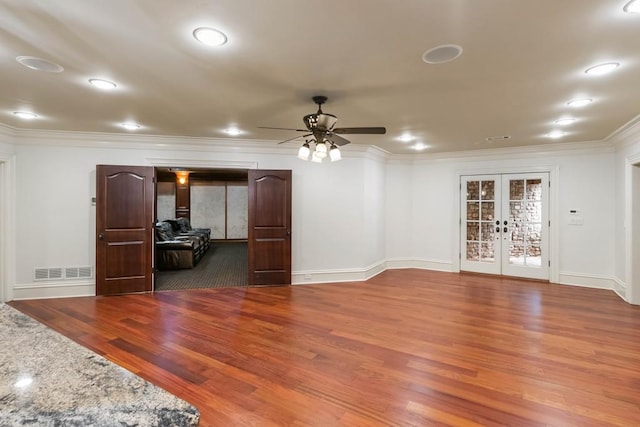 unfurnished living room featuring dark hardwood / wood-style floors, ceiling fan, crown molding, and french doors