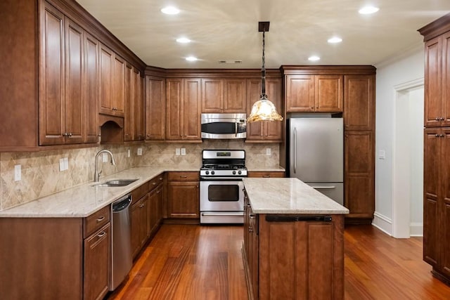 kitchen featuring a center island, sink, decorative light fixtures, dark hardwood / wood-style flooring, and stainless steel appliances