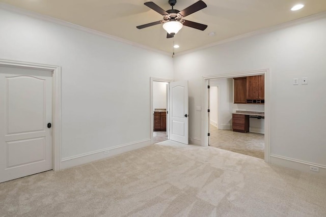 unfurnished bedroom with ceiling fan, ensuite bathroom, light colored carpet, and ornamental molding