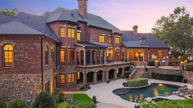 back house at dusk with a patio