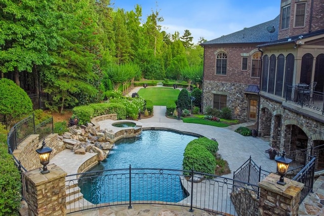 view of swimming pool with a lawn, a patio area, and an in ground hot tub