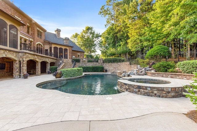 view of swimming pool featuring an in ground hot tub, pool water feature, and a patio area