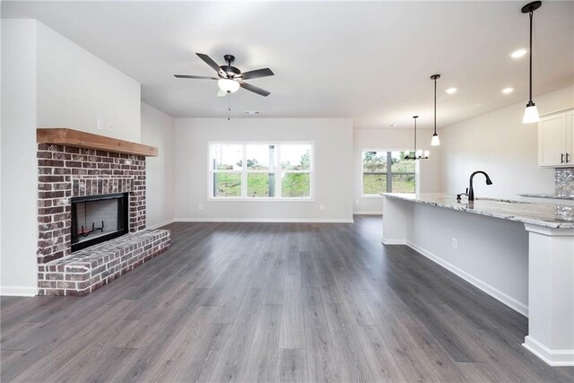 106 Harmony Farms Orch, Eatonton, GA 31024 - unfurnished living room with a fireplace, dark hardwood / wood-style flooring, ceiling fan with notable chandelier, and sink
