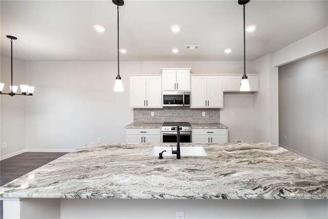106 Harmony Farms Orch, Eatonton, GA 31024 - kitchen with white cabinetry, stainless steel appliances, tasteful backsplash, a spacious island, and pendant lighting