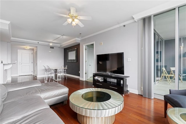 living area with crown molding, a ceiling fan, baseboards, and wood finished floors