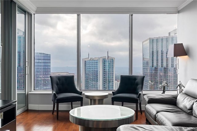 living room with baseboards, ornamental molding, a city view, and wood finished floors