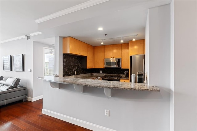 kitchen with baseboards, appliances with stainless steel finishes, light stone countertops, and tasteful backsplash