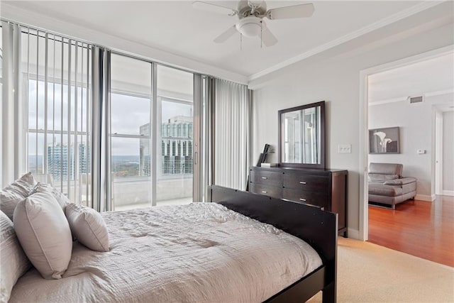 carpeted bedroom featuring crown molding, access to outside, ceiling fan, baseboards, and visible vents