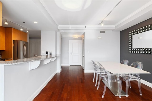 dining space featuring crown molding, track lighting, and baseboards