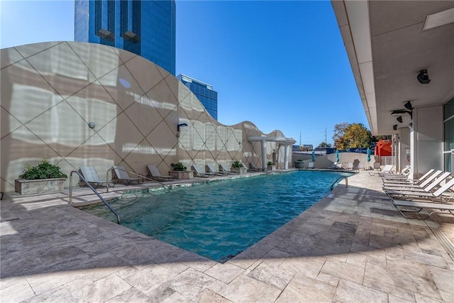 community pool featuring fence and a patio