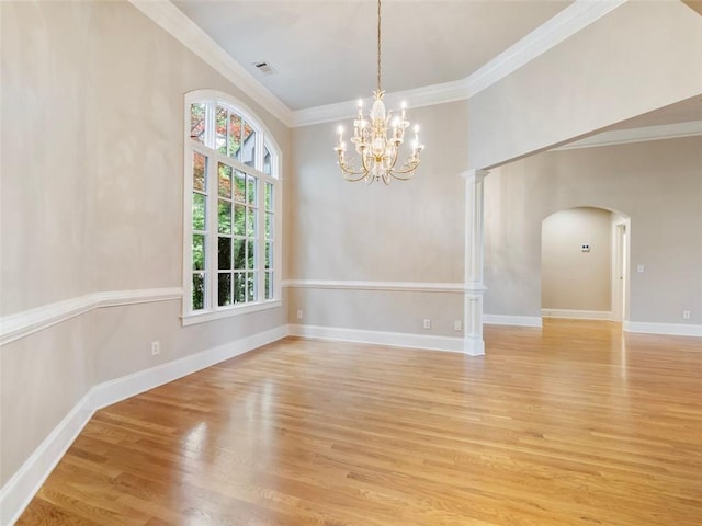 unfurnished dining area with an inviting chandelier, arched walkways, ornamental molding, visible vents, and light wood finished floors