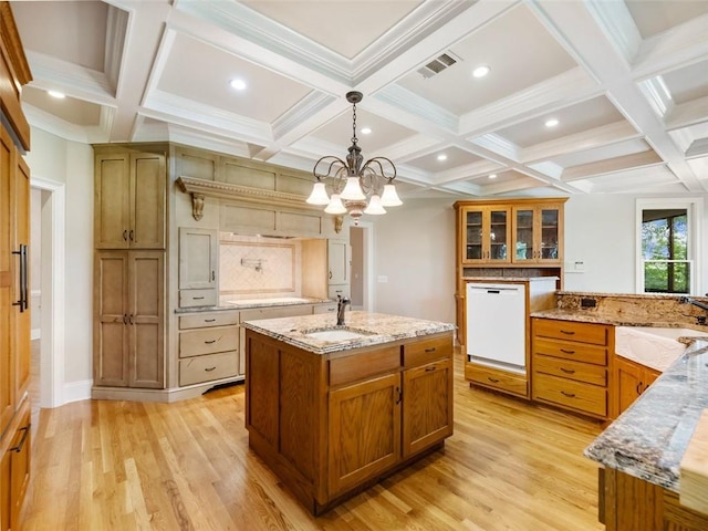 kitchen with a sink, visible vents, light wood finished floors, and dishwasher