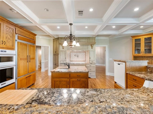 kitchen with light wood finished floors, visible vents, white appliances, and light stone countertops