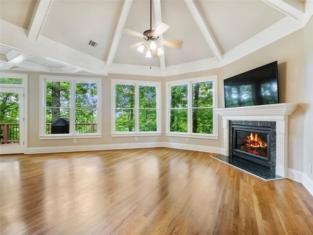 unfurnished living room featuring beamed ceiling, a ceiling fan, wood finished floors, and a high end fireplace