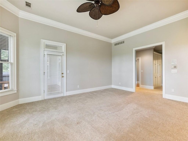 spare room featuring visible vents, light colored carpet, crown molding, and ceiling fan