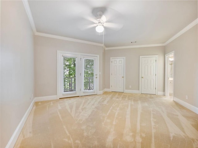 unfurnished room featuring light carpet, baseboards, crown molding, and ceiling fan