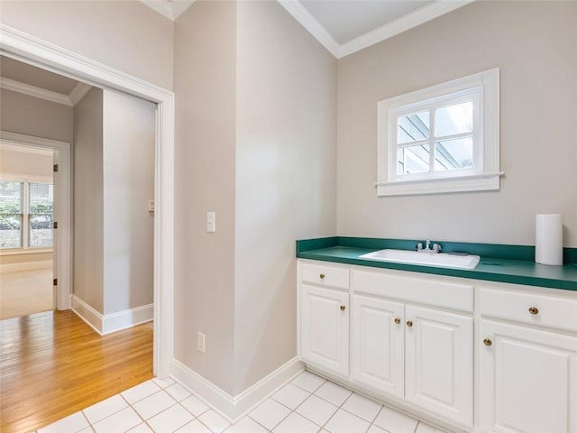 bathroom featuring crown molding, wood finished floors, a sink, and baseboards