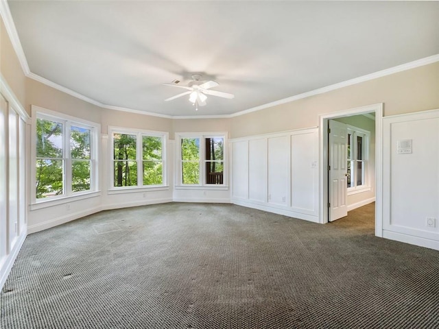 interior space with ornamental molding, ceiling fan, and carpet