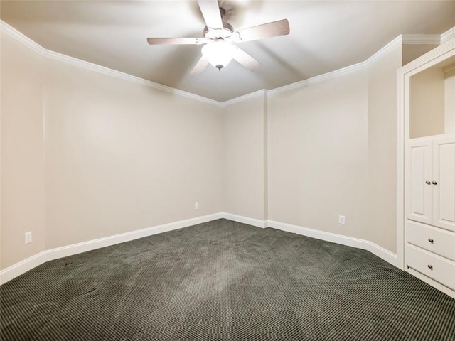empty room with ceiling fan, dark colored carpet, ornamental molding, and baseboards
