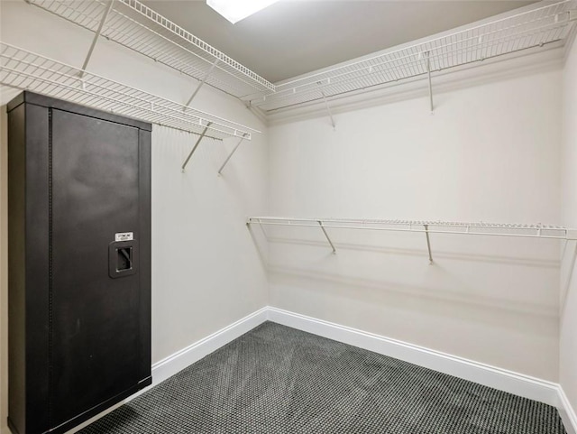 walk in closet featuring dark carpet