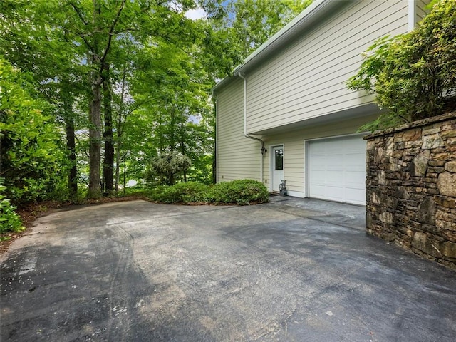 view of side of property with driveway and a garage