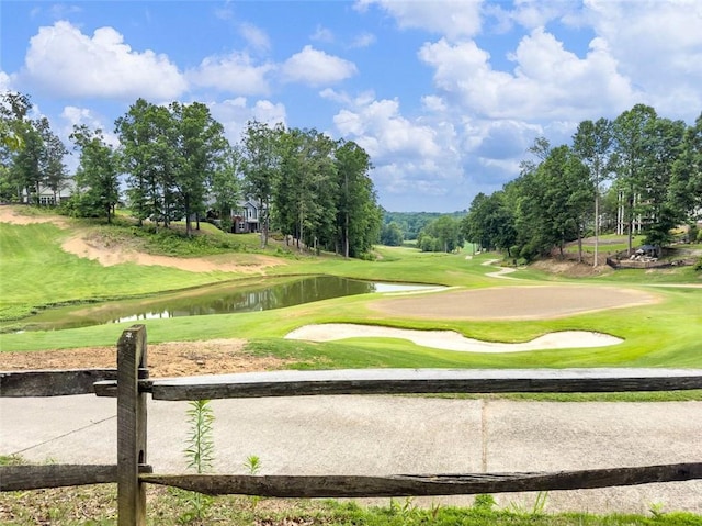 surrounding community featuring a water view, view of golf course, and a yard