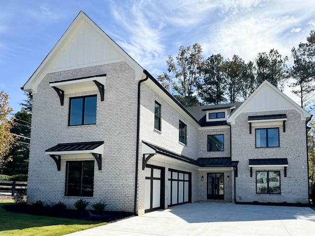 modern inspired farmhouse with a garage and a front lawn