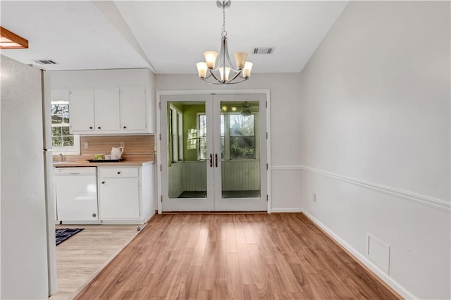 doorway featuring a notable chandelier, visible vents, baseboards, and light wood-style floors