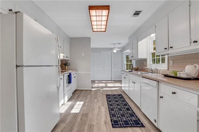 kitchen featuring visible vents, white cabinets, white appliances, and light wood-style floors