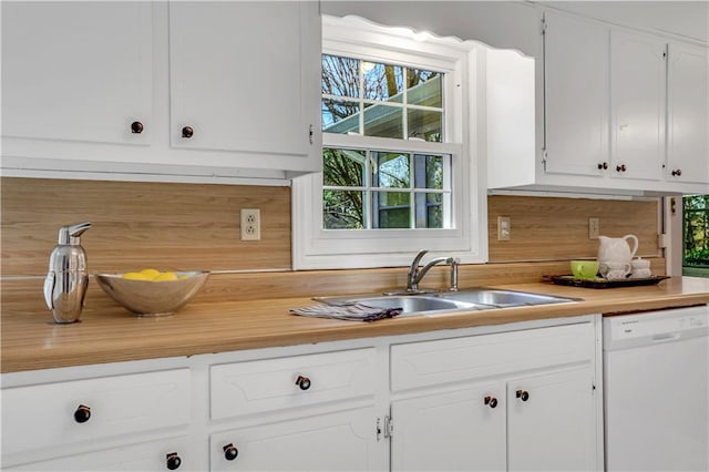 kitchen featuring a sink, dishwasher, white cabinets, and light countertops