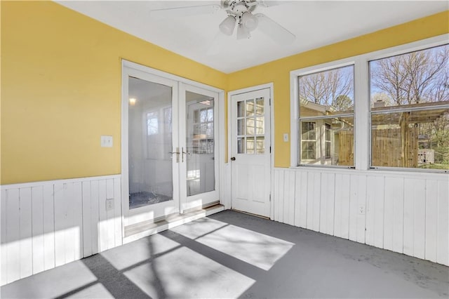 unfurnished sunroom with a ceiling fan and french doors