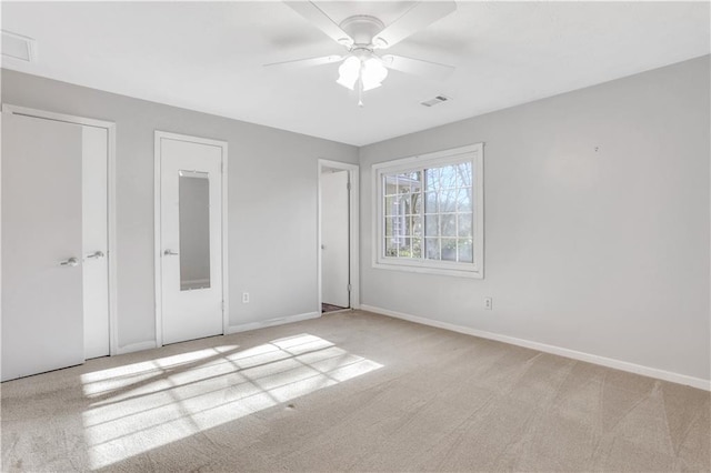 unfurnished bedroom with visible vents, carpet flooring, a ceiling fan, and baseboards