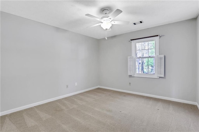 carpeted empty room featuring visible vents, baseboards, and a ceiling fan