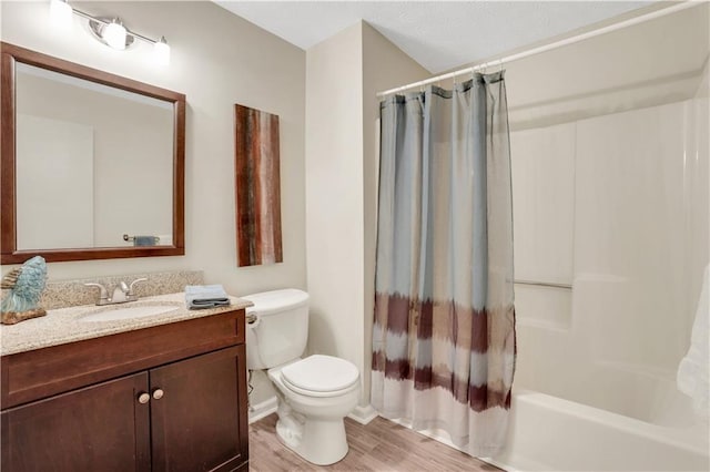 full bathroom featuring shower / tub combo with curtain, toilet, wood finished floors, and vanity