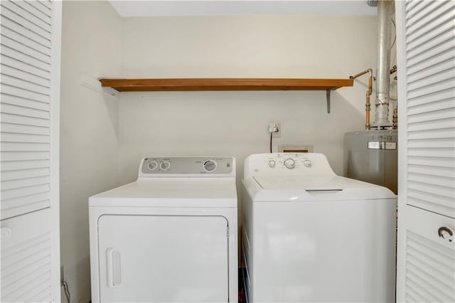 clothes washing area featuring water heater, laundry area, and independent washer and dryer