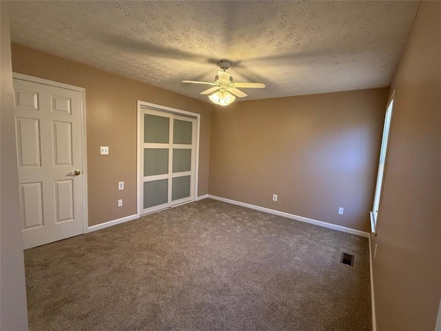 unfurnished room with baseboards, carpet, visible vents, and a ceiling fan