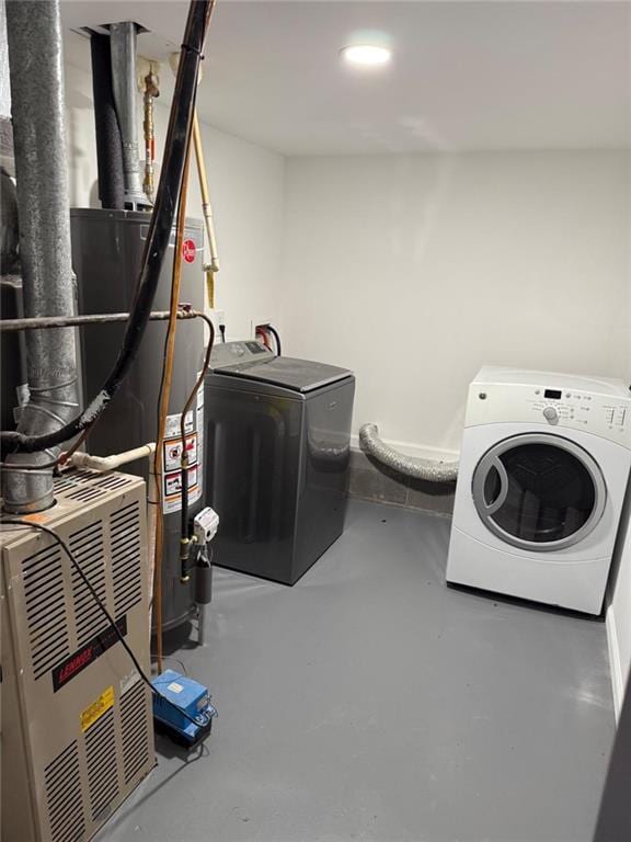 clothes washing area with laundry area, washing machine and clothes dryer, and gas water heater