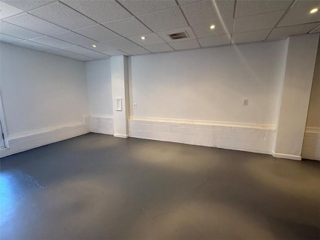 basement with a paneled ceiling, visible vents, and recessed lighting