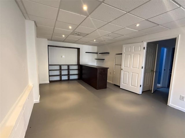 interior space with concrete flooring, freestanding refrigerator, baseboards, and recessed lighting