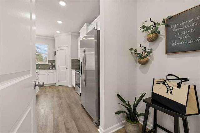 corridor featuring crown molding, sink, and light wood-type flooring