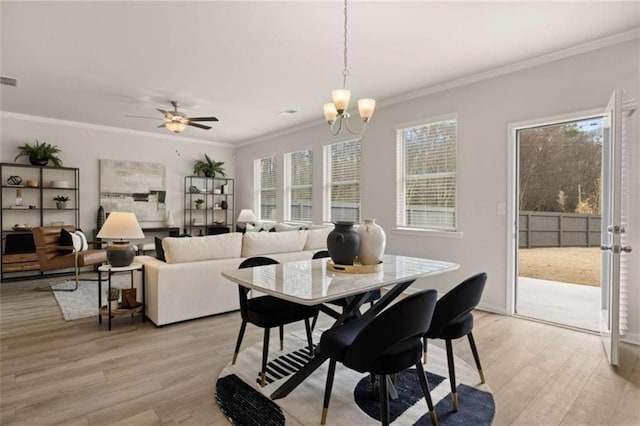 dining room with crown molding, light hardwood / wood-style flooring, and ceiling fan with notable chandelier