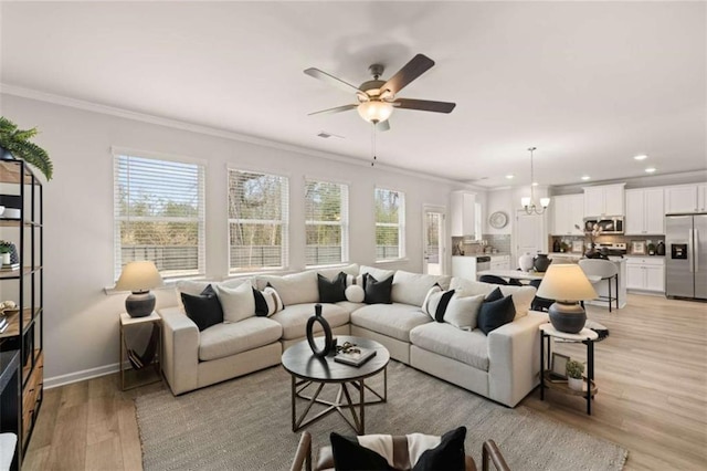 living room featuring ornamental molding, ceiling fan with notable chandelier, and light wood-type flooring