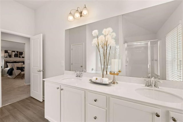 bathroom featuring vanity, an enclosed shower, hardwood / wood-style flooring, and vaulted ceiling