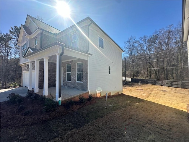 view of side of property with a garage and covered porch