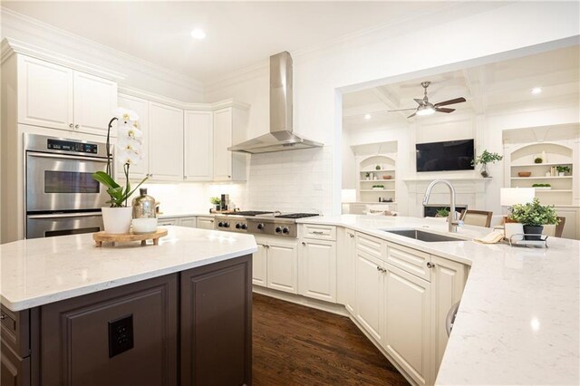 kitchen featuring wall chimney exhaust hood, a kitchen island, dark brown cabinetry, and stainless steel appliances