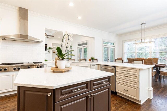 kitchen featuring a peninsula, appliances with stainless steel finishes, a center island, and white cabinets