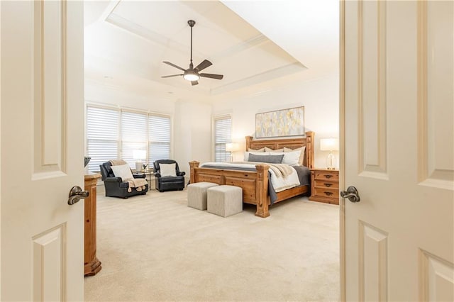 carpeted bedroom featuring a raised ceiling and ceiling fan