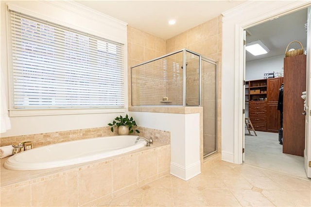 bathroom with a stall shower, a walk in closet, tile patterned flooring, and a garden tub