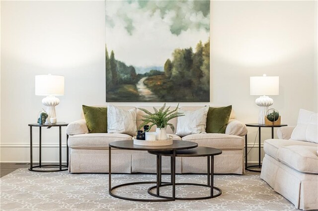 living room with ornamental molding, wood finished floors, and an inviting chandelier