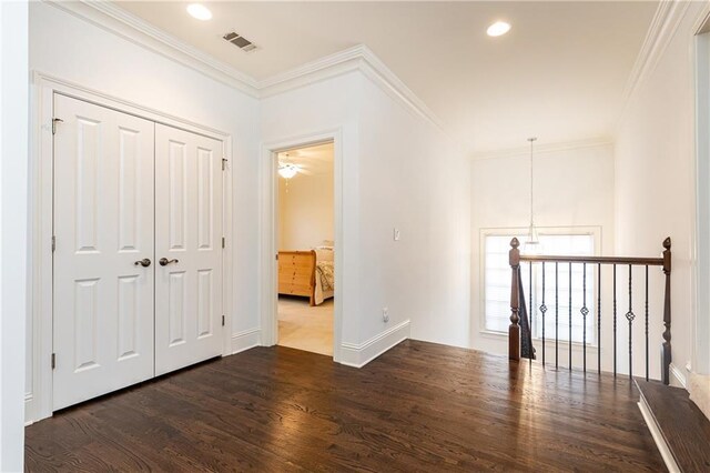 living area with light wood-style flooring, ceiling fan, crown molding, and a glass covered fireplace